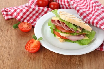 Tasty sandwich with ham on wooden table
