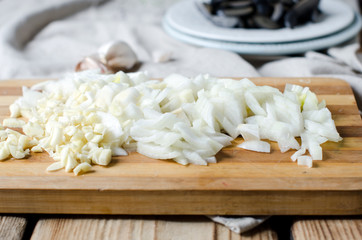 Obraz na płótnie Canvas Chopped onion and garlic on a cutting board
