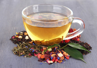 Cup of tea with aromatic dry tea on wooden background