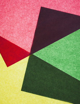 Pieces of colourful, recycled construction paper, overlapping and laid out at random.