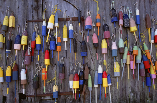 Fishing marker marine buoys or floats hanging on a fishing shed wall on the waterfront. 