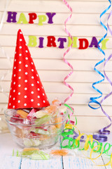 Tasty candies in vase with party hat