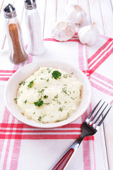 Delicious mashed potatoes with greens in bowl on table close-up