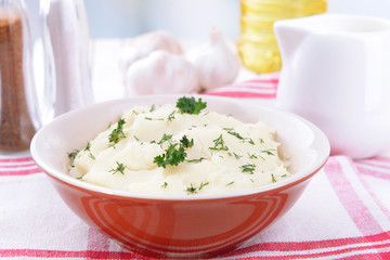 Delicious mashed potatoes with greens in bowl on table close-up
