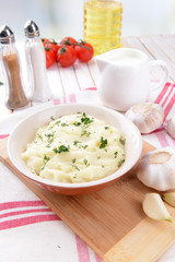 Delicious mashed potatoes with greens in bowl on table close-up