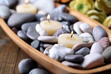 Fototapeta na wymiar Wooden bowl with spa stones and candles
