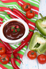 Tomato sauce in bowl on wooden table close-up