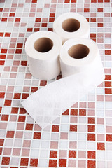 Color toilet paper rolls on bright background