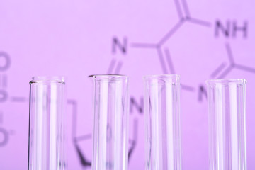 Test tube on written reaction formula background, close-up