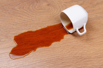 Overturned cup of coffee on floor close-up