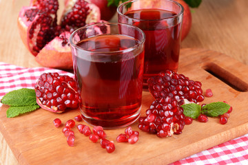 Ripe pomegranates with juice on table close-up