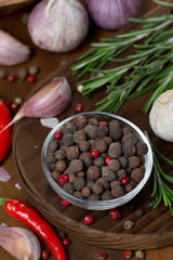 dried peppers, garlic, chilli and rosemary on a wooden board