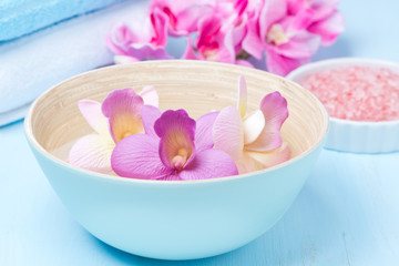 Obraz na płótnie Canvas flowers in a blue bowl, towels and sea salt for the spa