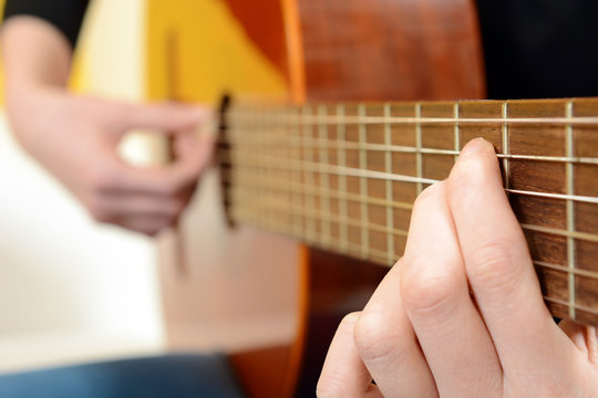 Frau spielt Akustik-Gitarre