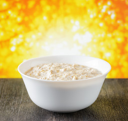 Bowl of oat porridge on nature background