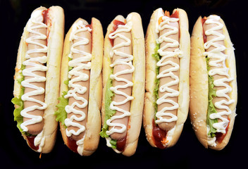 hot dog with mustard and tomato sauce Isolated on black backgrou