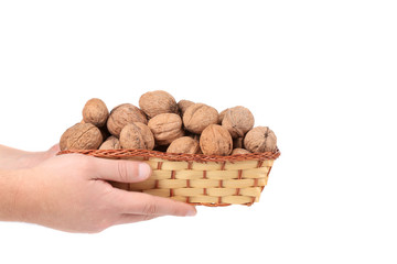 Hand hold walnuts in a wicker basket