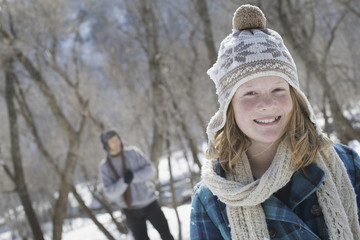 Smiling girl with bobble hat and scarf outdoors