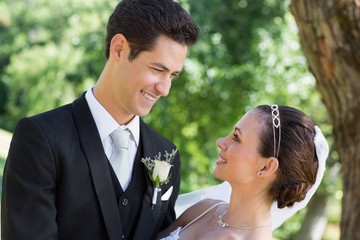 Bride and groom looking at each other in garden
