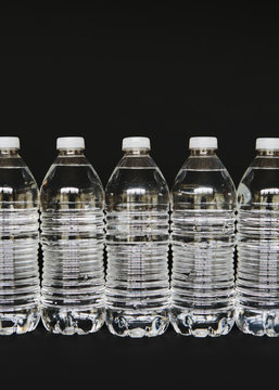 Row of clear, plastic water bottles filled with filtered water