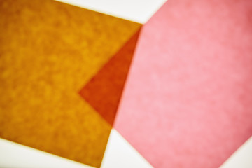 Two pieces of recycled construction paper,  brown and pink with a small overlapping triangle.
