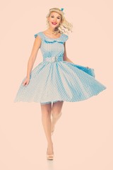 Sexy coquette blond pin up style young woman in blue dress