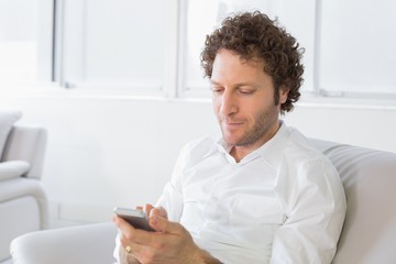 Relaxed man text messaging at home