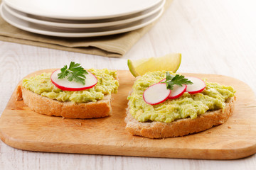 Two sandwiches with avocado and radish