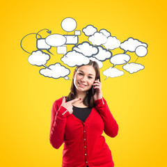 Young girl talking on mobile over yellow background