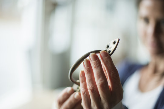 An antique store in a small town, with objects and furniture from the past. A woman holding a door handle or bracket. 