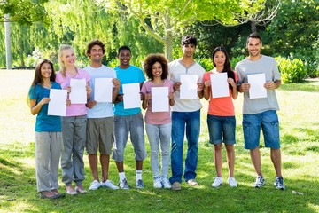 Confident students holding blank papers