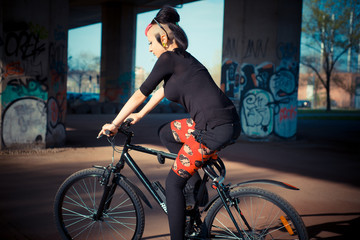 young beautiful punk dark girl riding bike