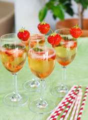 Summer cocktail with champagne, peppermint and fresh strawberrie