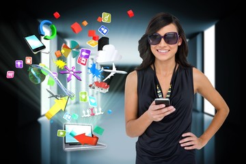 Glamorous brunette using smartphone with app icons and laptop