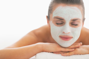 Woman with revitalising mask on face laying on massage table