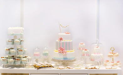 Elegant sweet table with big cake, cupcakes, cake pops on dinner