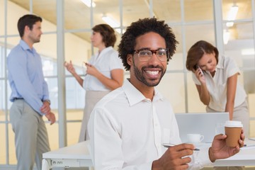 Fototapeta premium Businessman holding disposable coffee cup with colleagues at