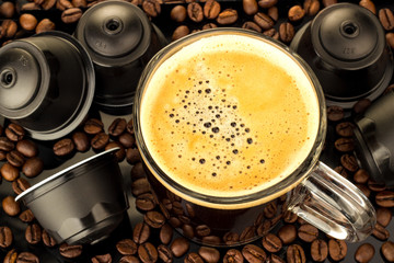 Gläserne Tasse  Kapseln und Kaffeebohnen