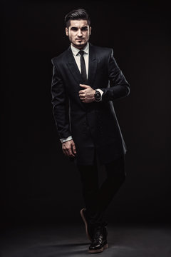 Full-length portrait of handsome stylish man in elegant black su