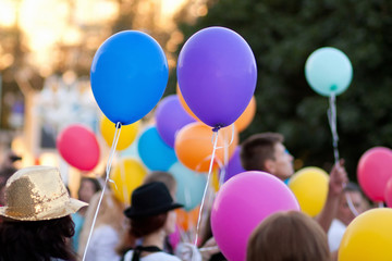 children hold colored balloons
