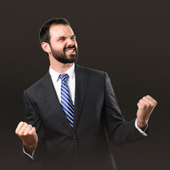 Young business man winner over black background