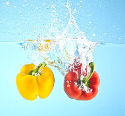 red and yellow pepper splashed into water