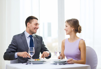 smiling couple eating appetizers at restaurant