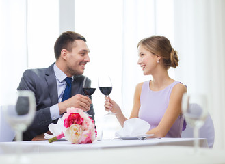 young couple with glasses of wine at restaurant