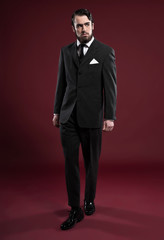 Retro 1900 fashion man with beard wearing grey suit and black ti