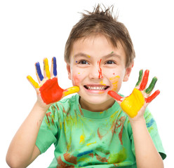 Portrait of a cute boy playing with paints