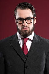 Retro 1900 fashion man with beard wearing grey suit red tie and