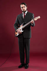 Retro fashion music man with beard wearing grey suit and red tie