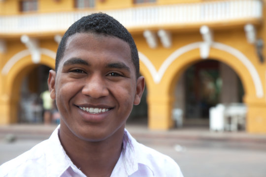 Young guy in a colonial town laughing at camera
