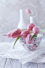 Obraz na płótnie Canvas Still Life with Pink Tulips on a Tea Cup